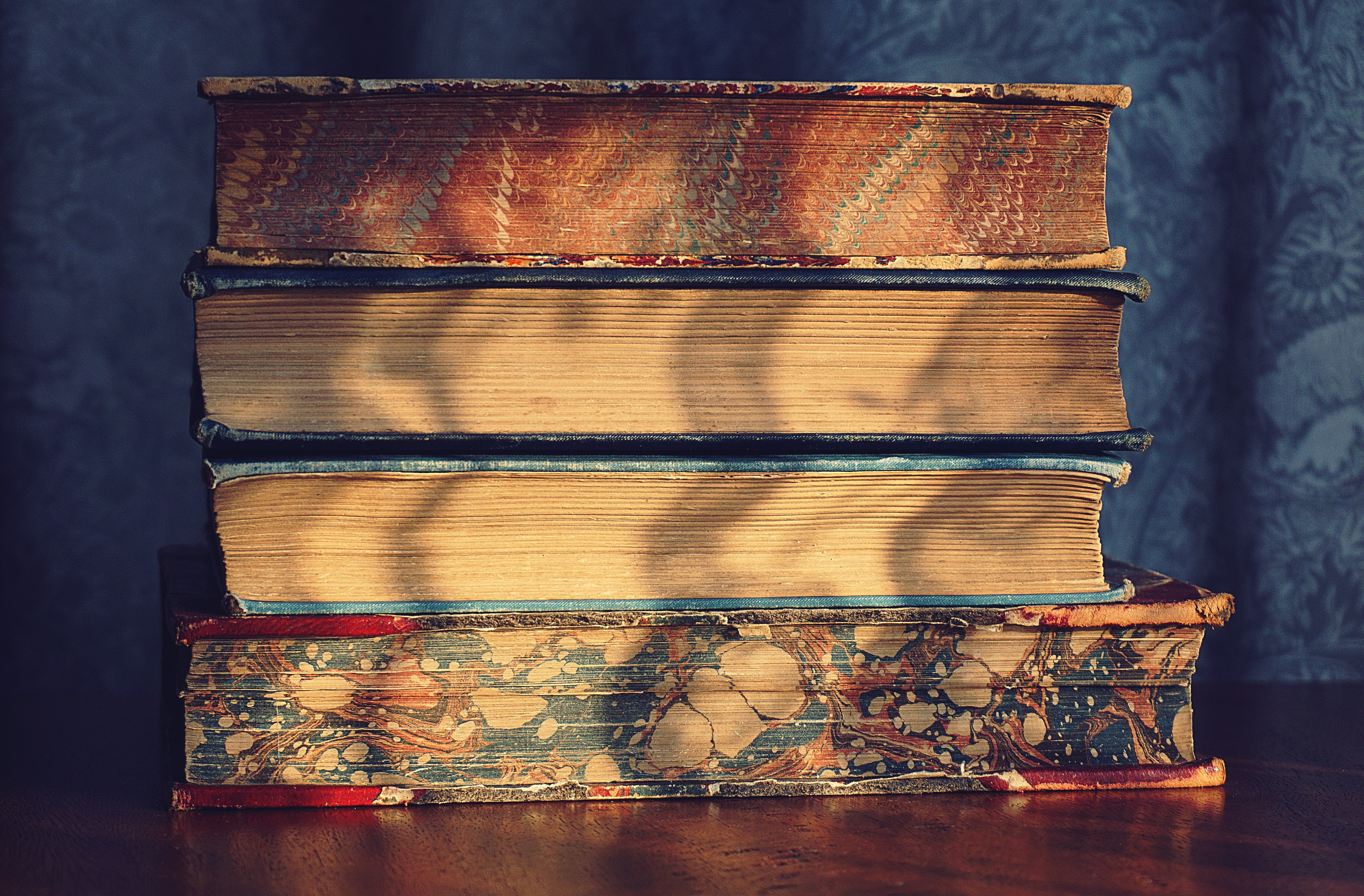 four books stacked on their sides, pages visible